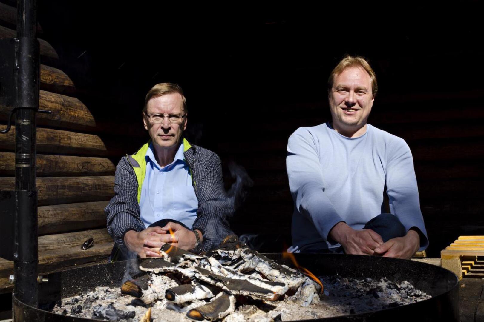 Tapio Lahola sekä Kalajoen Rotaryklubin presidentti Toni Määttänen Pleunan oiotussa kodassa uusitun grillin äärellä.