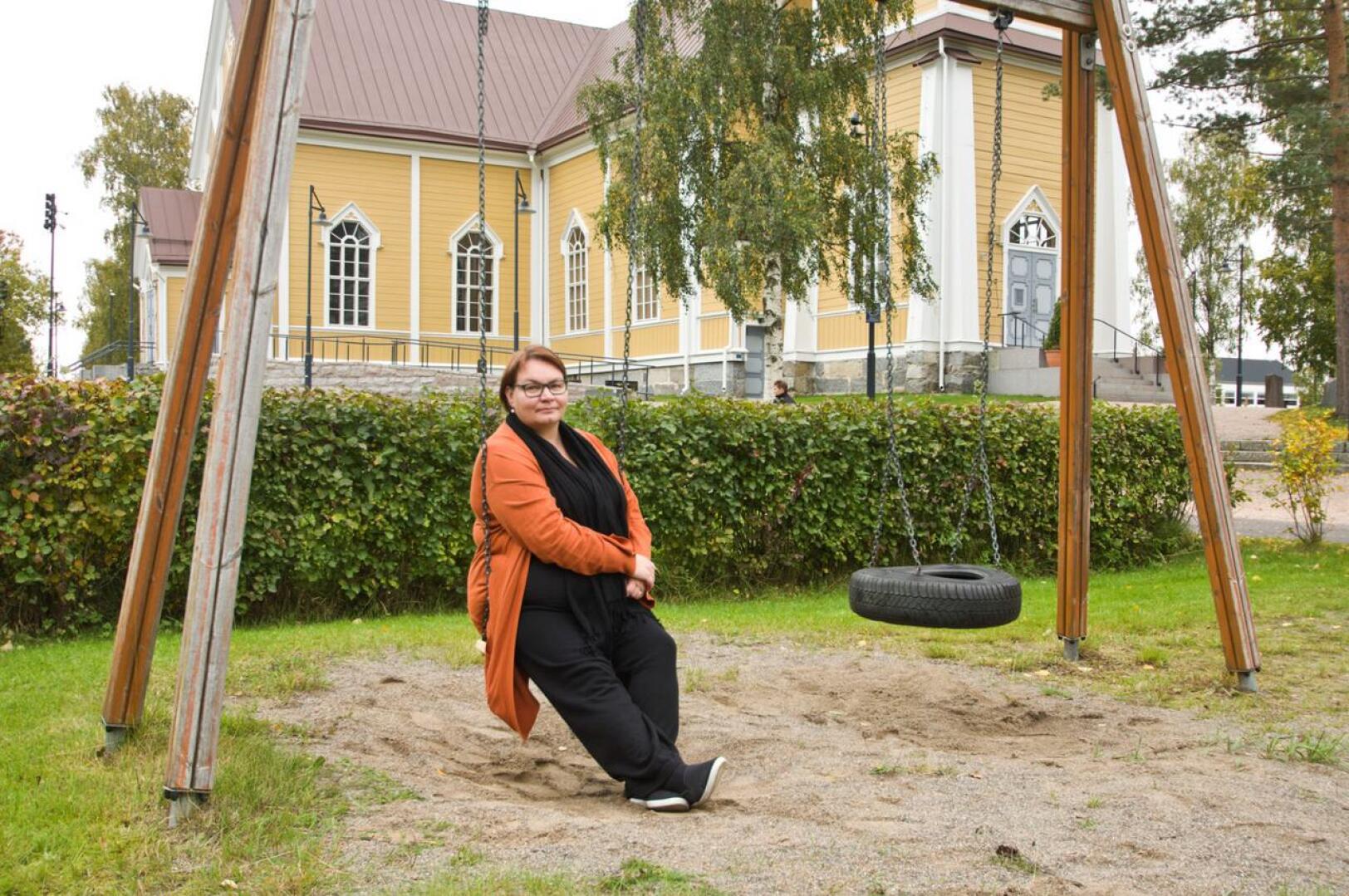Kirkkoherra Sanna Jukkola asettui kuvaan siihen, minne suunnitellaan seurakunnan uurnalehtoa.