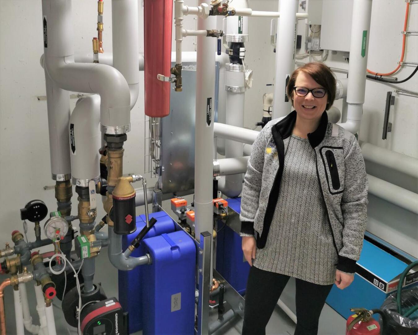 Energia-asiantuntija Henna Lohtander Kalajoen kaupungintalon lämmönjakohuoneessa.