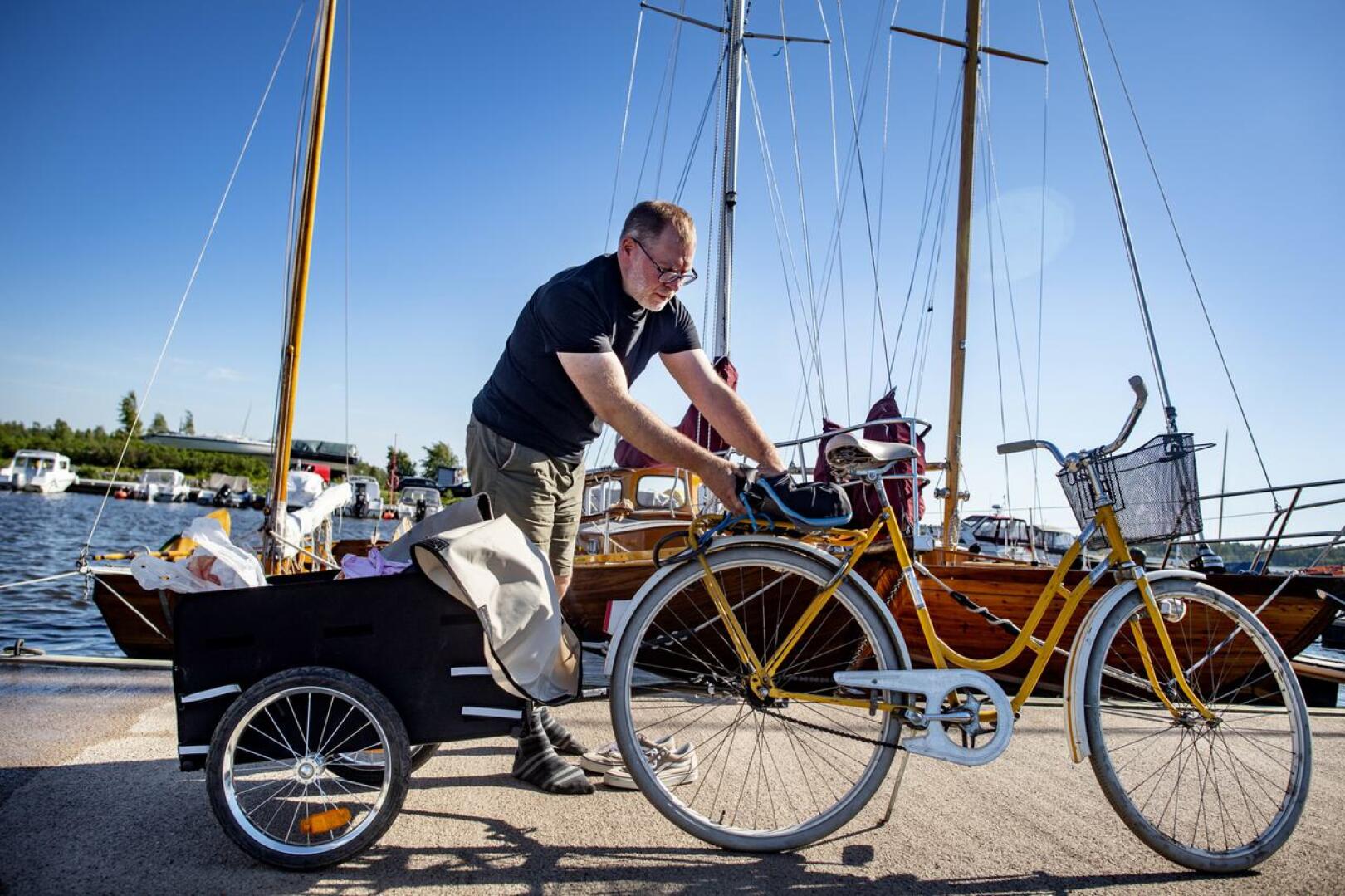 Erik Vierkens on saapunut Mustakarin venesatamaan polkupyörällä, jonka perässä hän vetää kärryä, jolla kuljettaa tavaroitansa. 
