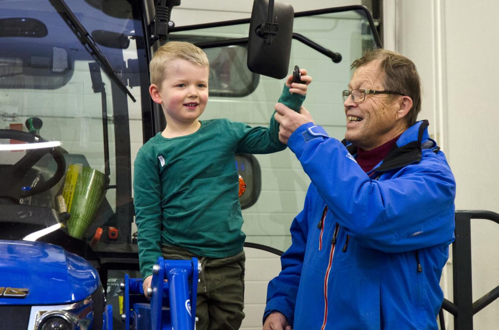 Kuulan arvontavastaava Väinö Haapakoski luovutti Aapo Kiviojalle traktorin avaimet. Traktoriin kuuluu etukuormaaja, lumikauha, ja ruohonleikkuri.