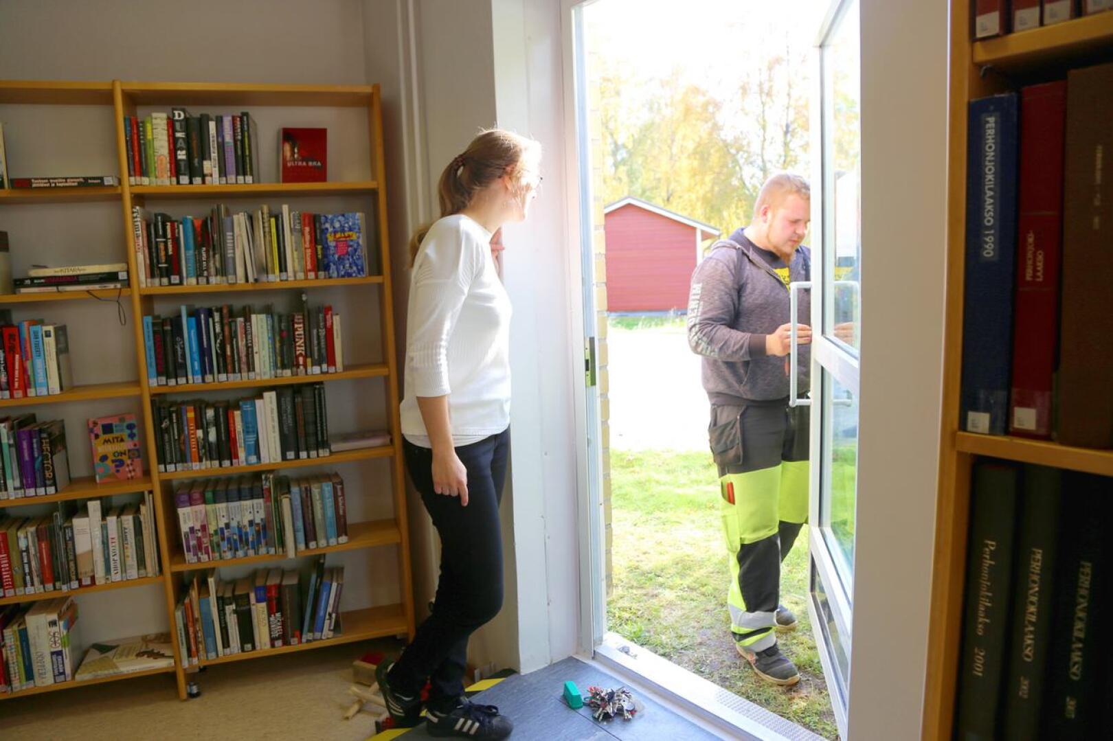 Kirjastossa työskentelevä Maria Nikula seuraa, kun kiinteistöhoitaja Markus Harjukoski korjaa hätäuloskäynnin rikottua sähkölukkoa. Tällä kertaa lukko saatiin kuitenkin kuntoon. 