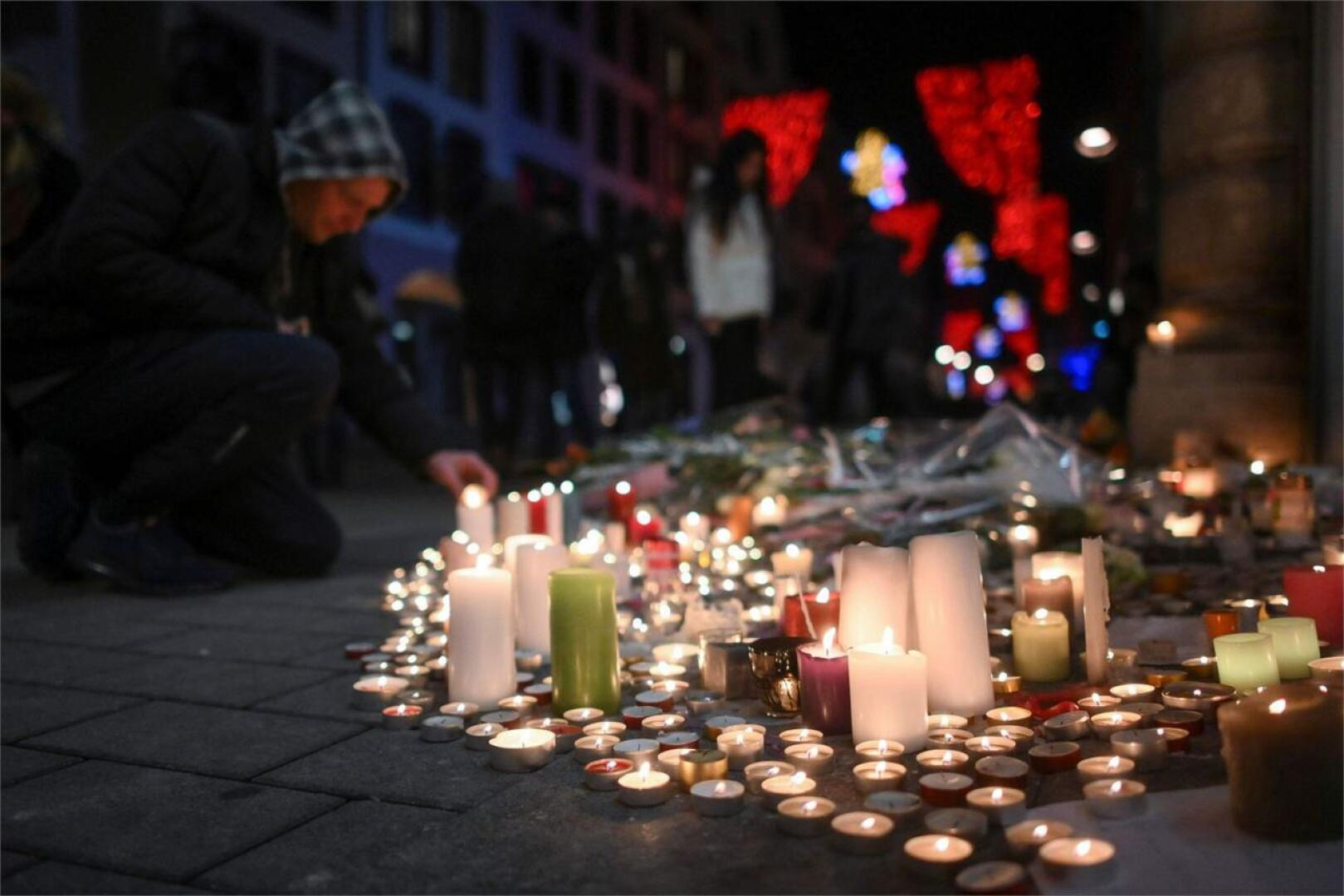 Mies sytytti kynttilöitä iskun uhrien muistoksi Strasbourgissa Ranskassa torstaina. LEHTIKUVA/AFP