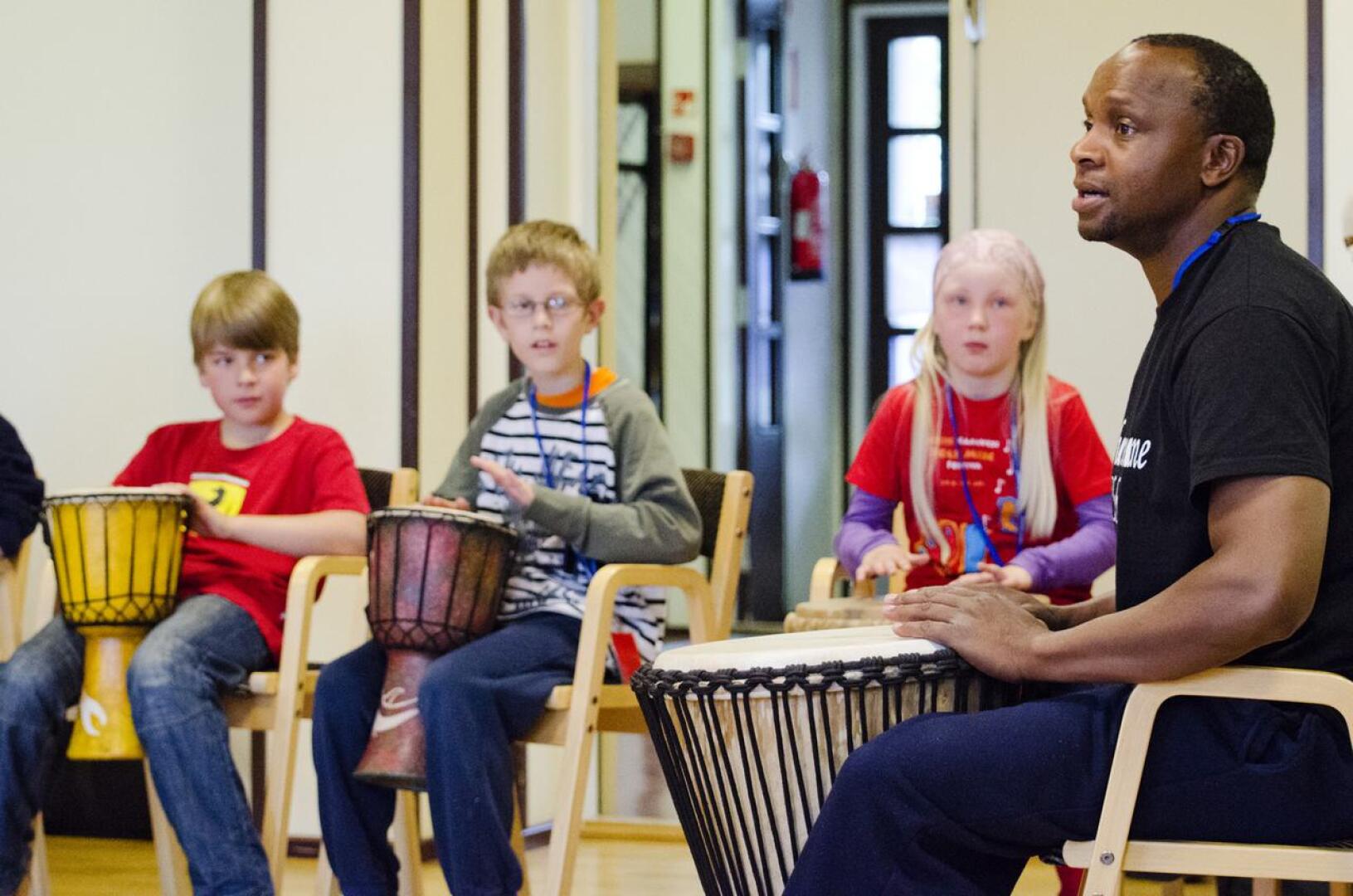 Lapset pääsivät harjoittelemaan rumpujen soittoa tansanialaiseen tyyliin Arnold Chiwalalan johdolla. 