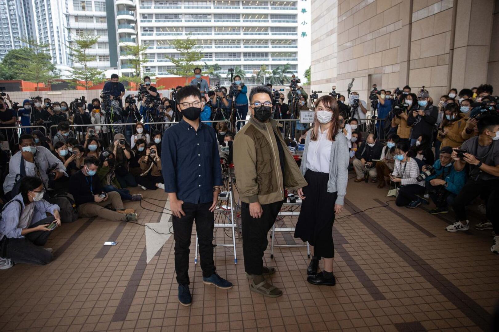 Joshua Wong (vas.), Ivan Lam ja Agnes Chow kuvattiin oikeustalon edustalla Hongkongissa maanantaina.