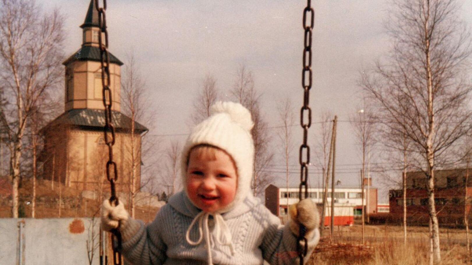 Jonna Autio noin kaksivuotiaana kirkon takana keinumassa ensimmäisen kotinsa lähistöllä Kannuksessa.