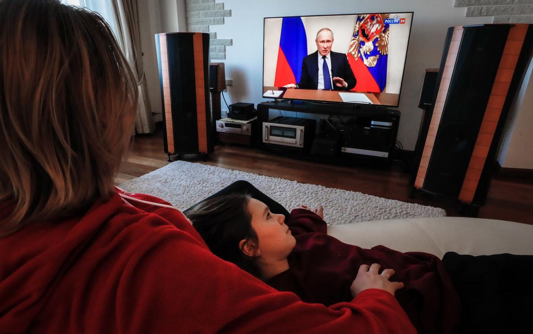 Venäläisperhe seurasi presidentti Vladimir Putinin puhetta television välityksellä keskiviikkona Domodedovon kaupungissa Venäjällä.