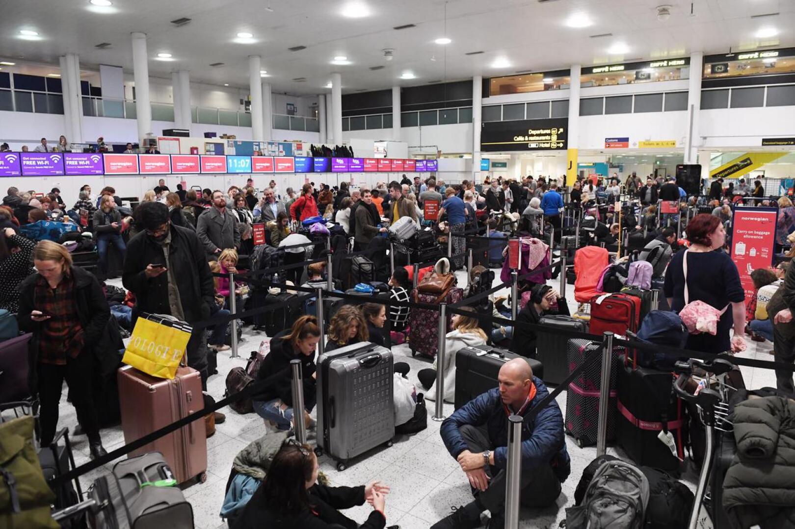  Häiriköivien droonien pysäyttämät matkustajat odottavat Gatwickin lentokentällä.  Lentokaaos on koskettanut yli 100 000 matkustajaa ja yli 700 lentoa.
