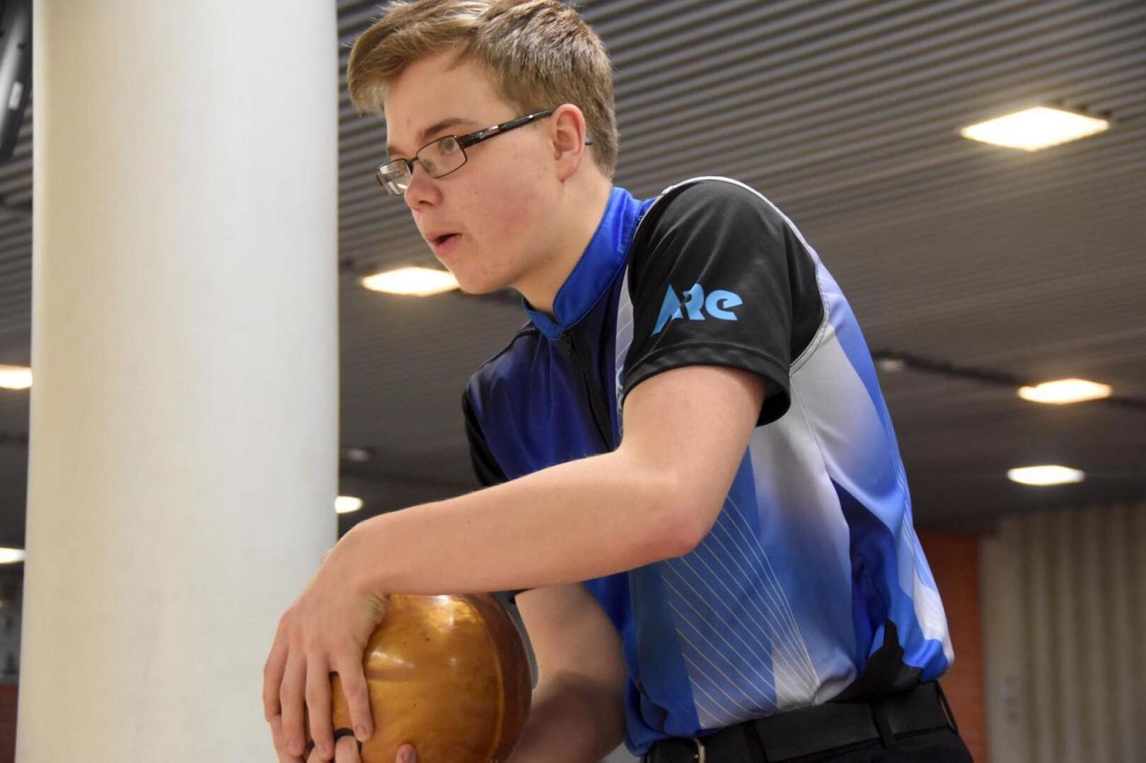 Simon Tissarinen heittää keilapalloa kahdella kädellä, kuten useimmat juniorit nykyisin.