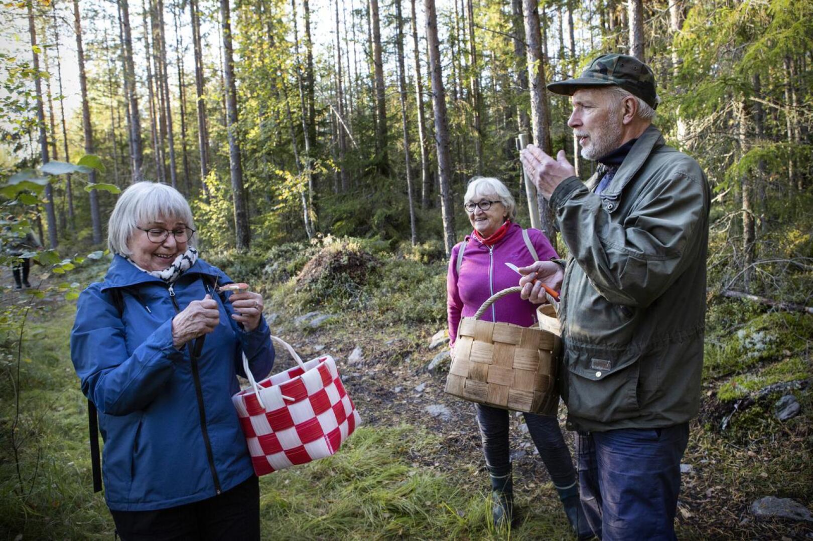 Sieniseuran puheenjohtaja Kenneth Bergroth opastaa sienten tunnistuksessa.– Sieniseuran mukana on turvallista tunnistaa sieniä ja kulkea metsässä, Pirkko-liisa Rahja ja Majlis Känsäkangas. 