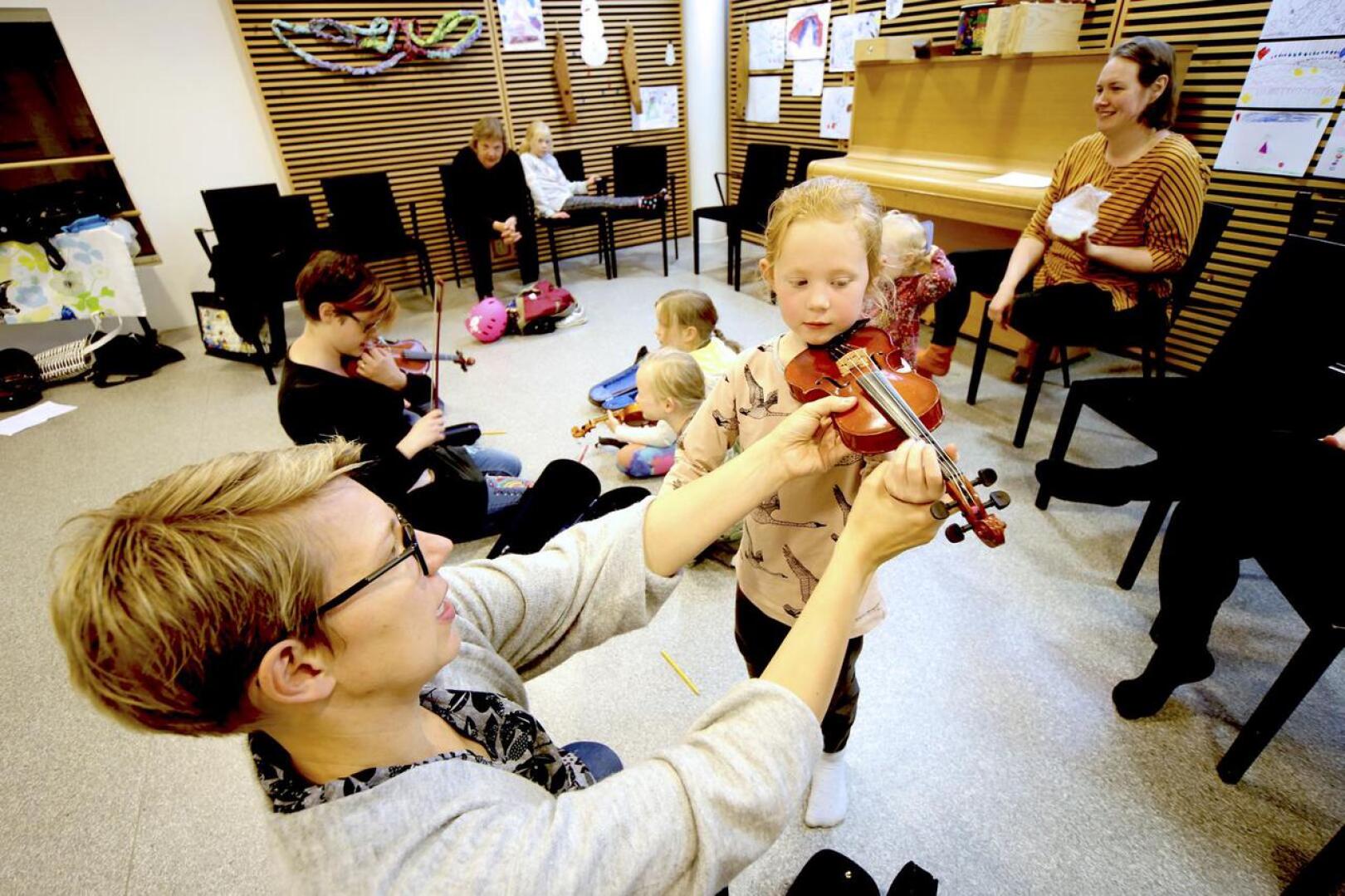 Siiri Järvelä sovittaa Eliida Timoselle viulua Näppäreiden järjestämällä ensimmäisellä alkeisryhmätunnilla. Eliida on haaveillut viulunsoitosta jo parin vuoden ajan ja nyt eskari-iässä soittotunnit tulivat ajankohtaisiksi. 