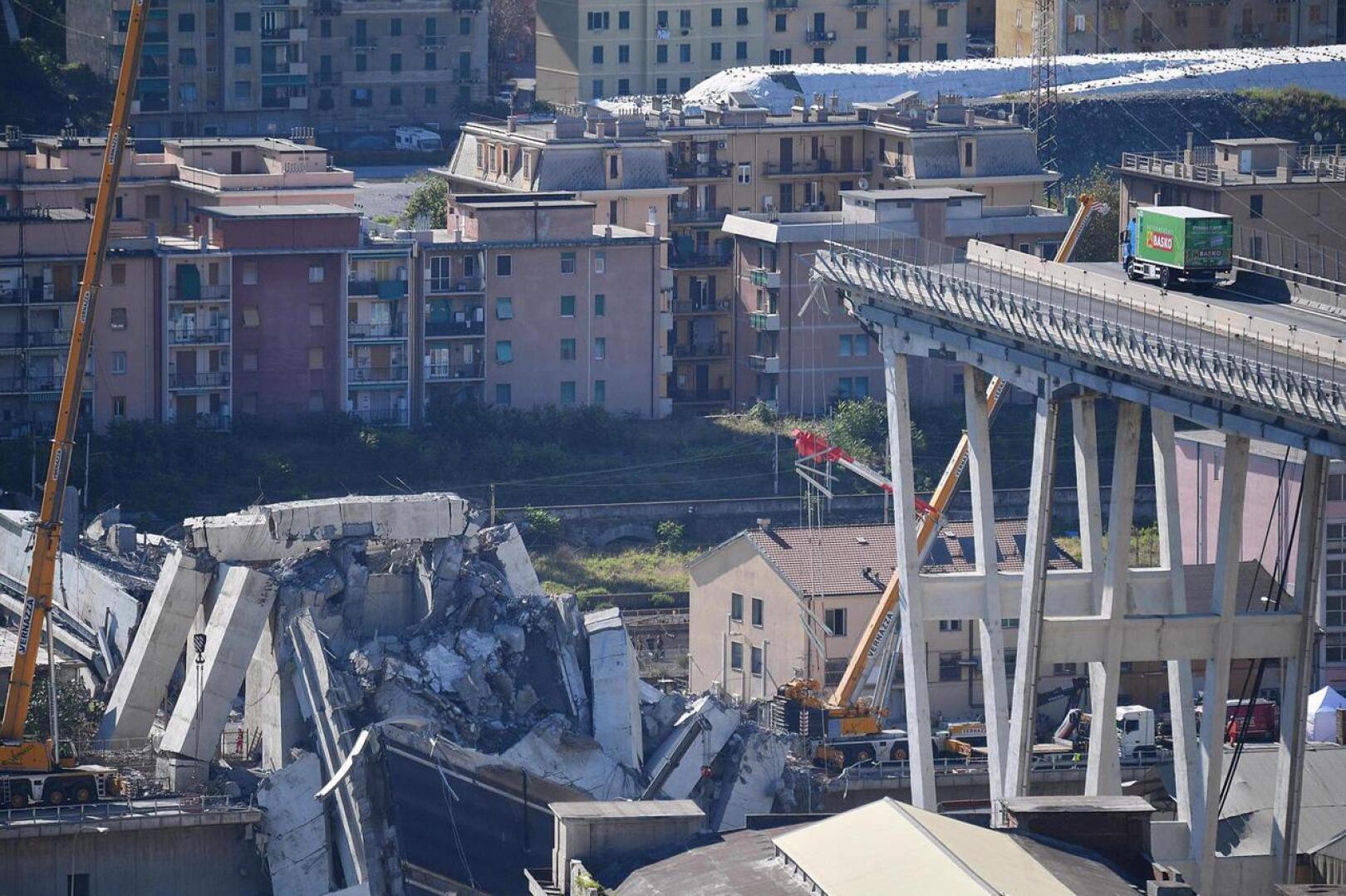 Vihreä kuorma-auto on pysäköity aivan Morandi-sillan sortuman partaalle. Tiistaina sattuneessa siltaturmassa on kuollut ainakin 37 ihmistä.