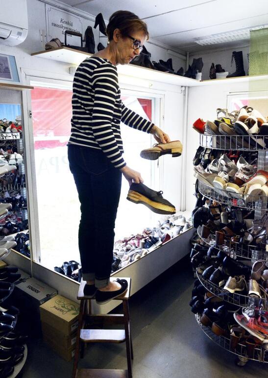 Kenkäkaupan katonrajassa on kenkiä 1950-luvulta 1980-luvulle saakka. Kaarina Juntunen esittelee puusta ja paperinarusta tehtyjä kenkiä - ne ovat esillä olleista kengistä ainoat, joita ei ole ollut kaupassa myynnissä.