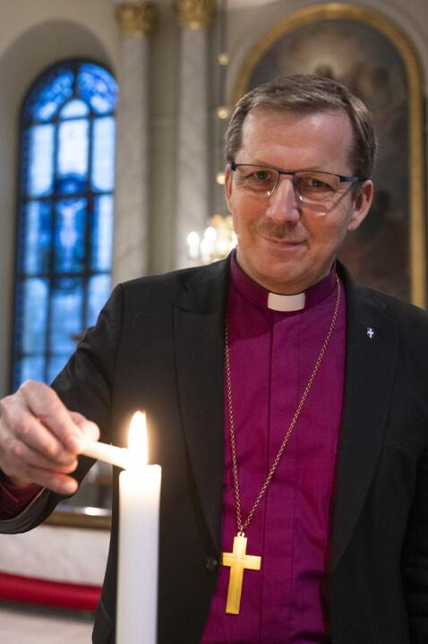 Piispa Jukka Keskitalo sytyttää kynttilän ja korostaa toivon merkitystä.