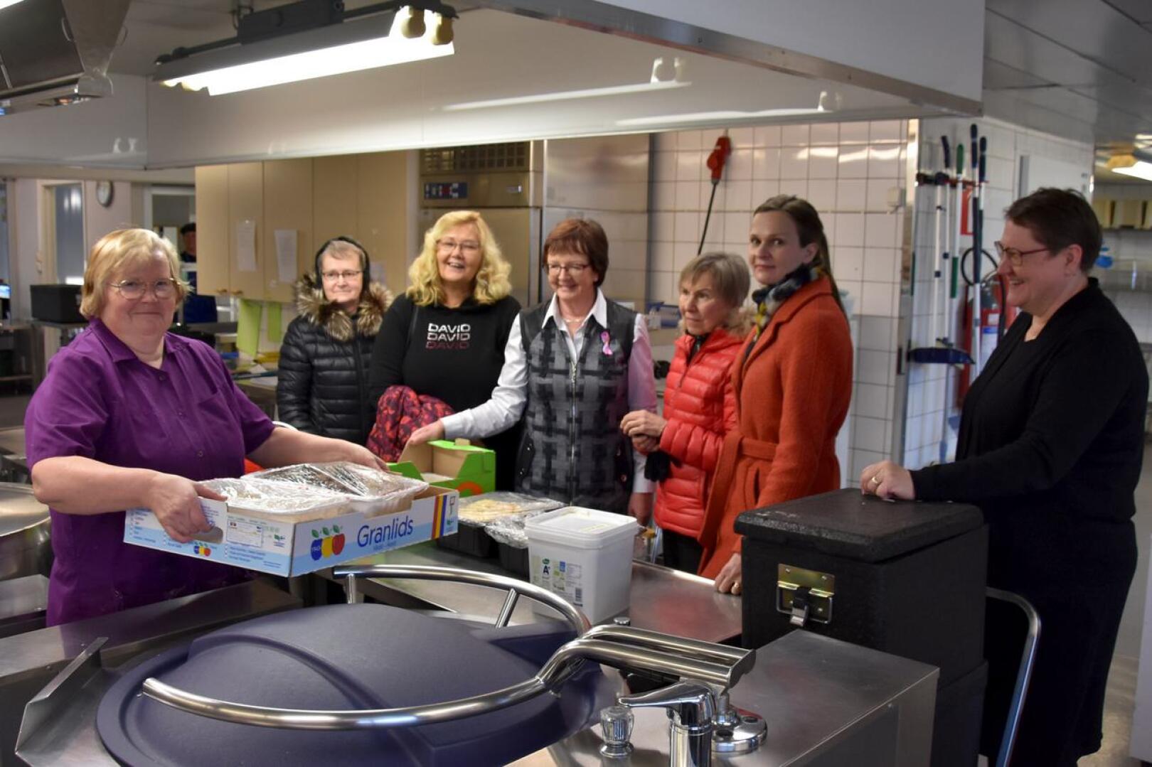 Ruoka-apua. Mervi Kangasniemi (vasemmalla) antamassa keittiöltä hävikkiruokaa, jota ovat hakemassa vasemmalta Laila Ylitalo, Hannele Ilola, Anja Törmä, Pirkko Päivärinta ja Ulla-Maija Karvonen. Sirpa Maliniemi oikealla.