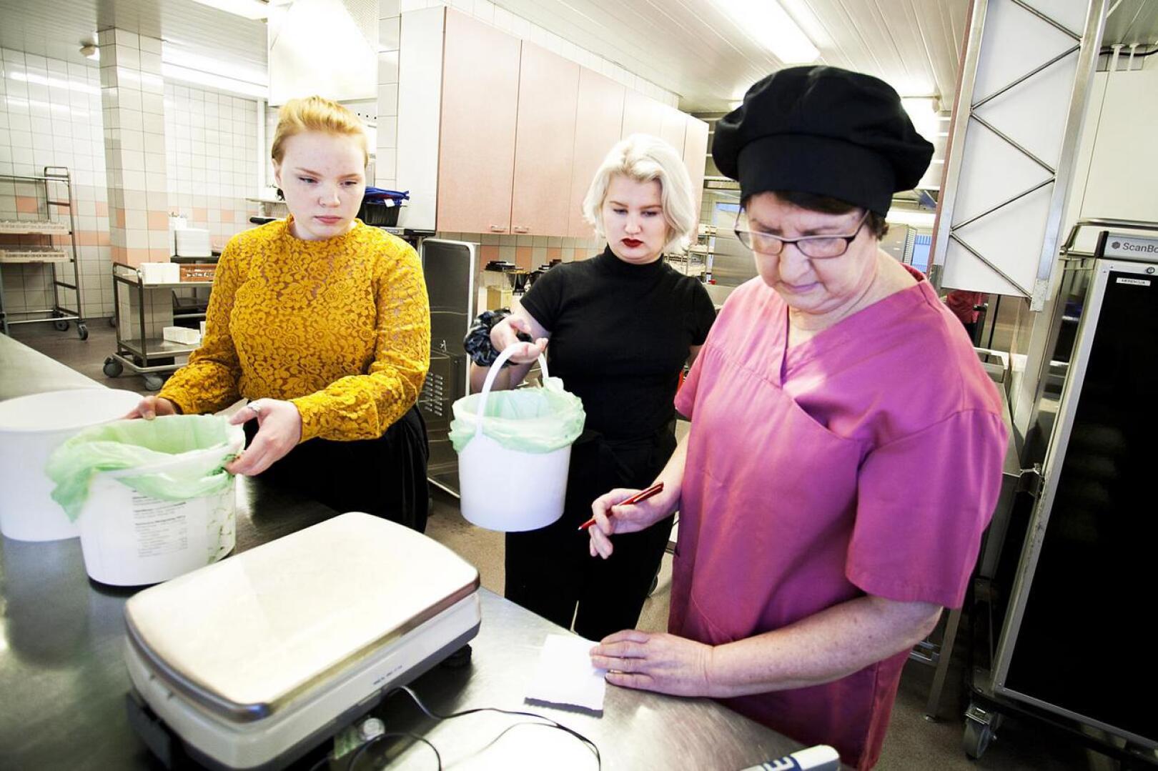Seida Karukka ja Pinja Kärkkäinen punnitsevat maanantain ruokahävikkiä ruokapalveluvastaava Raija Sorvarin kanssa. 