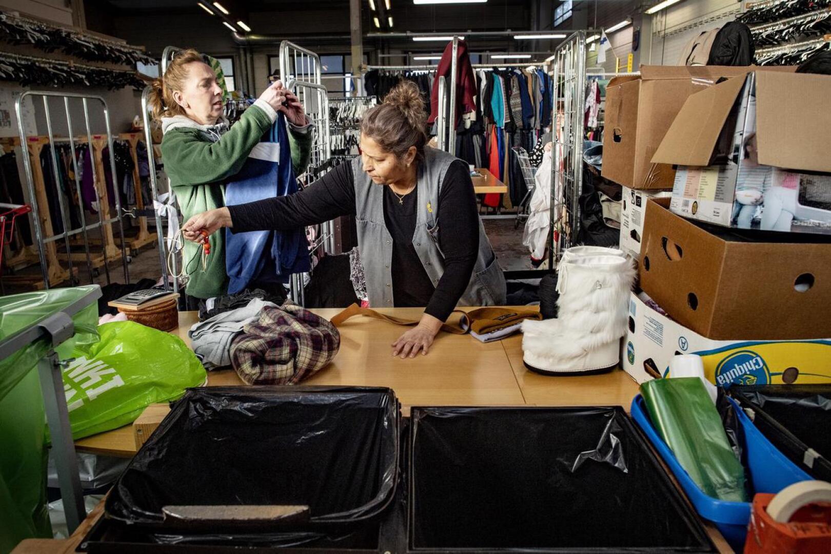Mikä menee myyntiin ja mikä hyväntekeväisyyteen? Fatima Långström ja Nedka Petkova lajittelevat kierrätykseen tulleita vaatteita Pietarsaaren Retron vaatevarastossa.