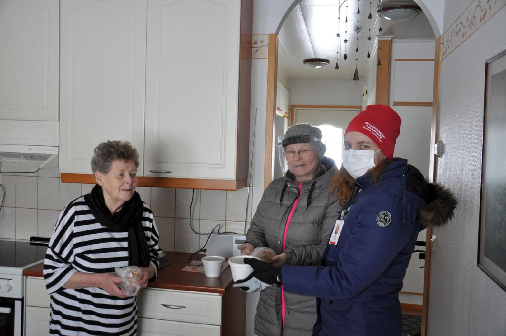 SPR:n ja seurakunnan vapaaehtoiset veivät laskiaisherkut yli sadan ikäihmisen kotiovelle. Leena Möttönen otti omansa vastaan iloisena.
