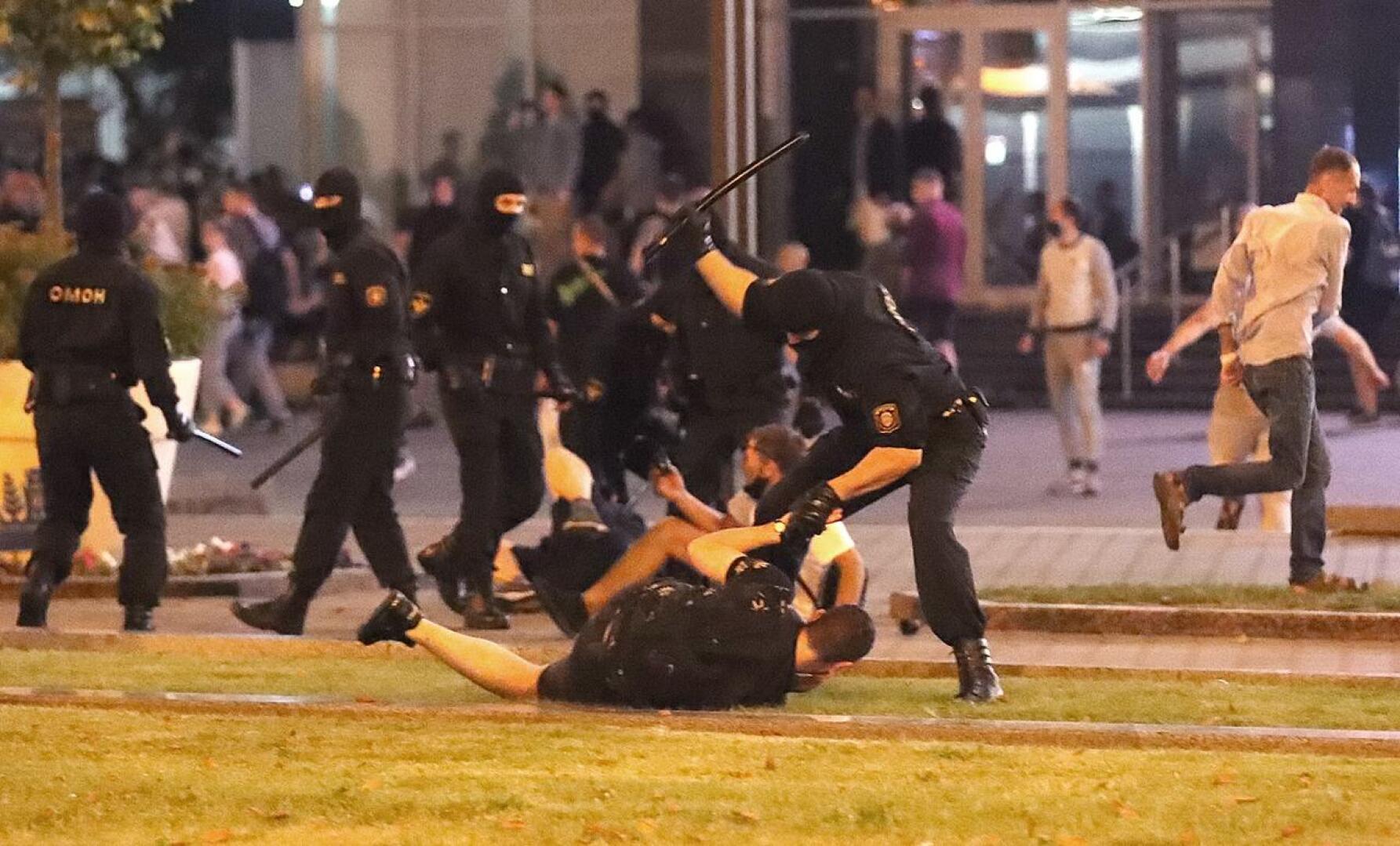 Poliisi lyö mielenosoittajaa Minskissä. Presidentinvaalien äänestyspaikkojen sulkeutumisen jälkeen mielenosoitukset alkoivat ympäri maata.