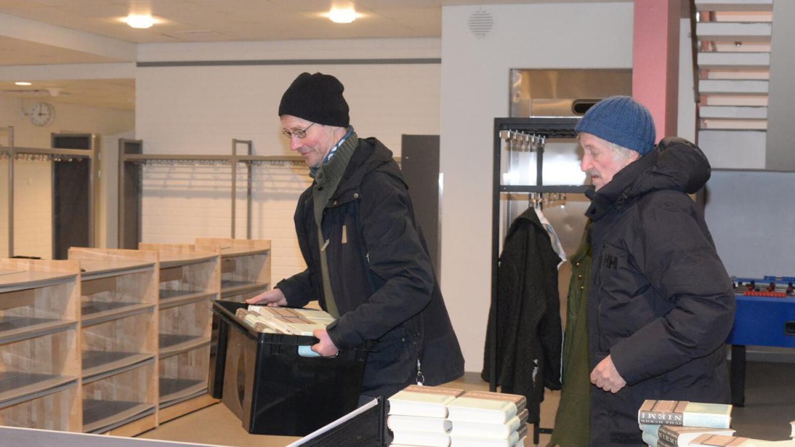 Juha Hurme ja Matti Rasi kantavat "Niemiä" Kisatien koululle hiki hatussa, tai ehkä paremminkn pipossa. 