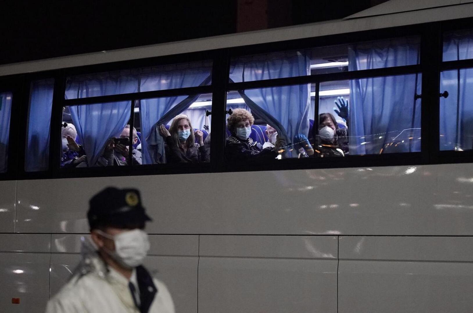 Yhdysvaltain kansalaiset heiluttivat bussin ikkunasta, kun heitä kuljetettiin pois Jokohaman satamasta.