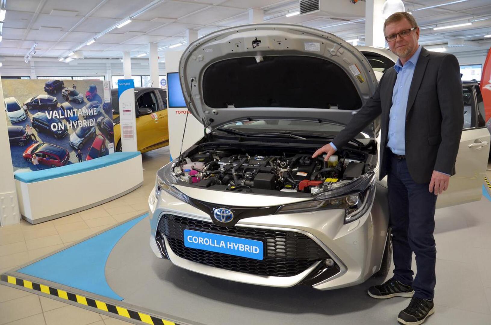 Pieni musta laatikko moottoritilassa paljastaa Corollan hybridiksi. Automyyjä Juha Saaren mukaan hybiridistä on tullut arkipäivän autotekniikkaa kuluttajille.