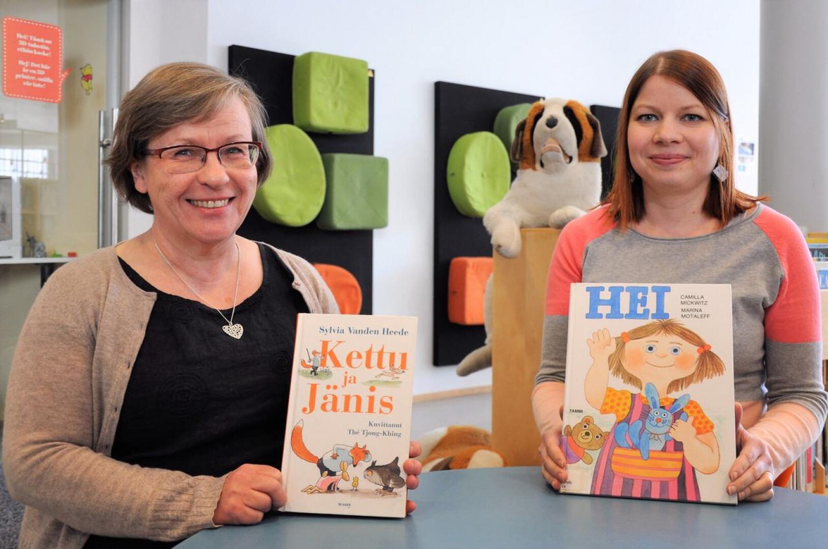 Mami Kolppanen (vas.) ja Minna Emmes johdattavat lapsia kirjojen maailmaan.
