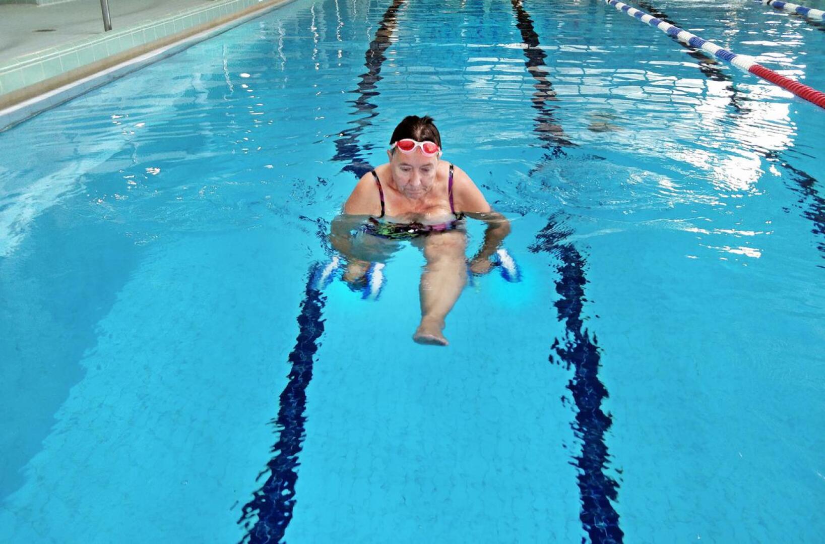 Eija Koski treenaamassa käsipainoilla Pietarsaaren uimahallin isossa altaassa. 