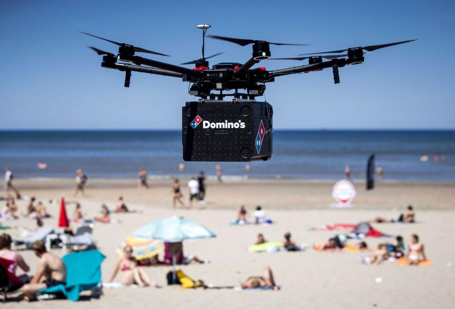 Drone-kuljetuksia kokeillaan muuallakin kuin Yhdysvalloissa – muun muassa Suomessa. Tässä pizzatoimitus saapuu ilmateitse hollantilaiselle uimarannalle.