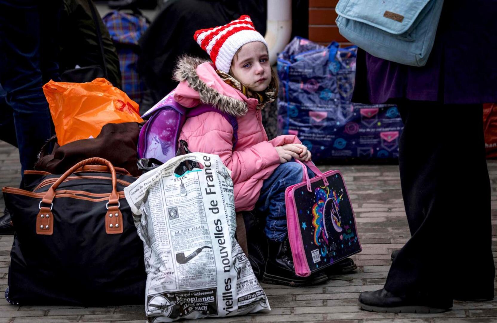 Pikkutyttö matkatavaroiden kanssa Krematorskin asemalla Itä-Ukrainassa.