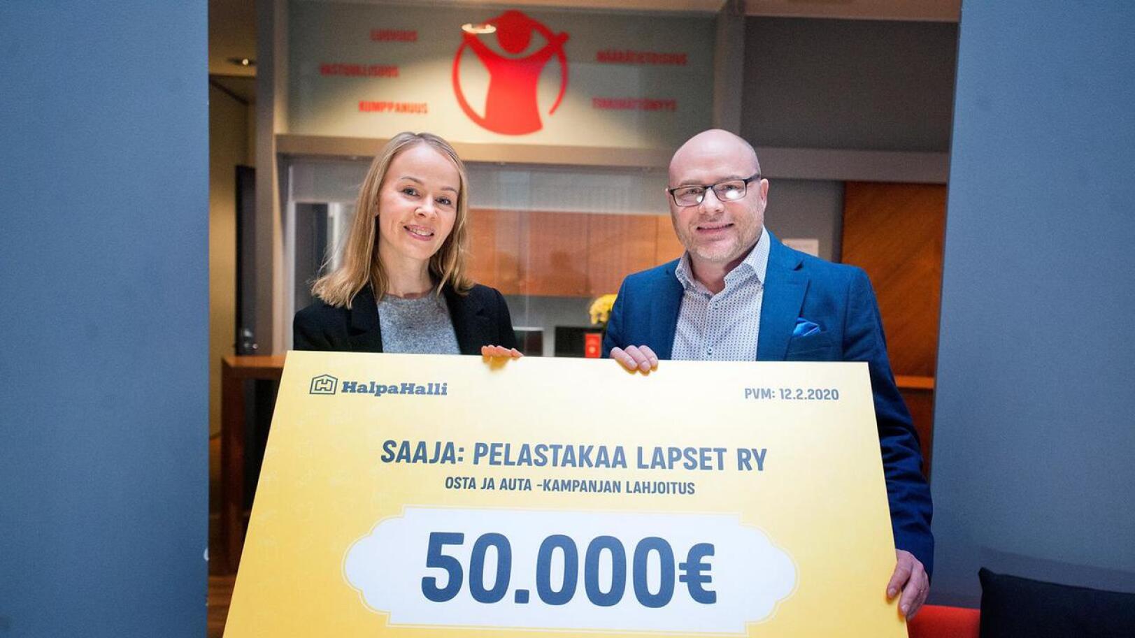 Yritystiimin vetäjä Heli Le otti Pelastakaa Lapset ry:n puolesta lahjoituksen vastaan HalpaHallin markkinointipäällikkö Juha Hakalalta. 