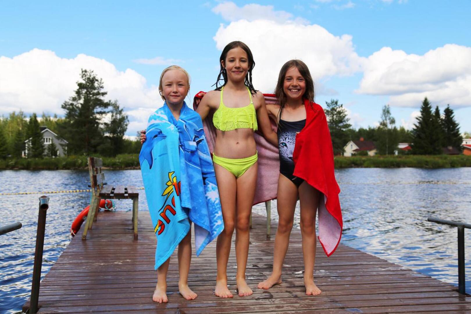 Emma Marjakangas (vas.) ja sisarukset Amanda ja Kiira Ságvári nauttivat uimisesta Hamarin uimarannalla Ylivieskassa. Tytöt sanovat, että vesi ei tunnu kylmältä jos aurinko paistaa.