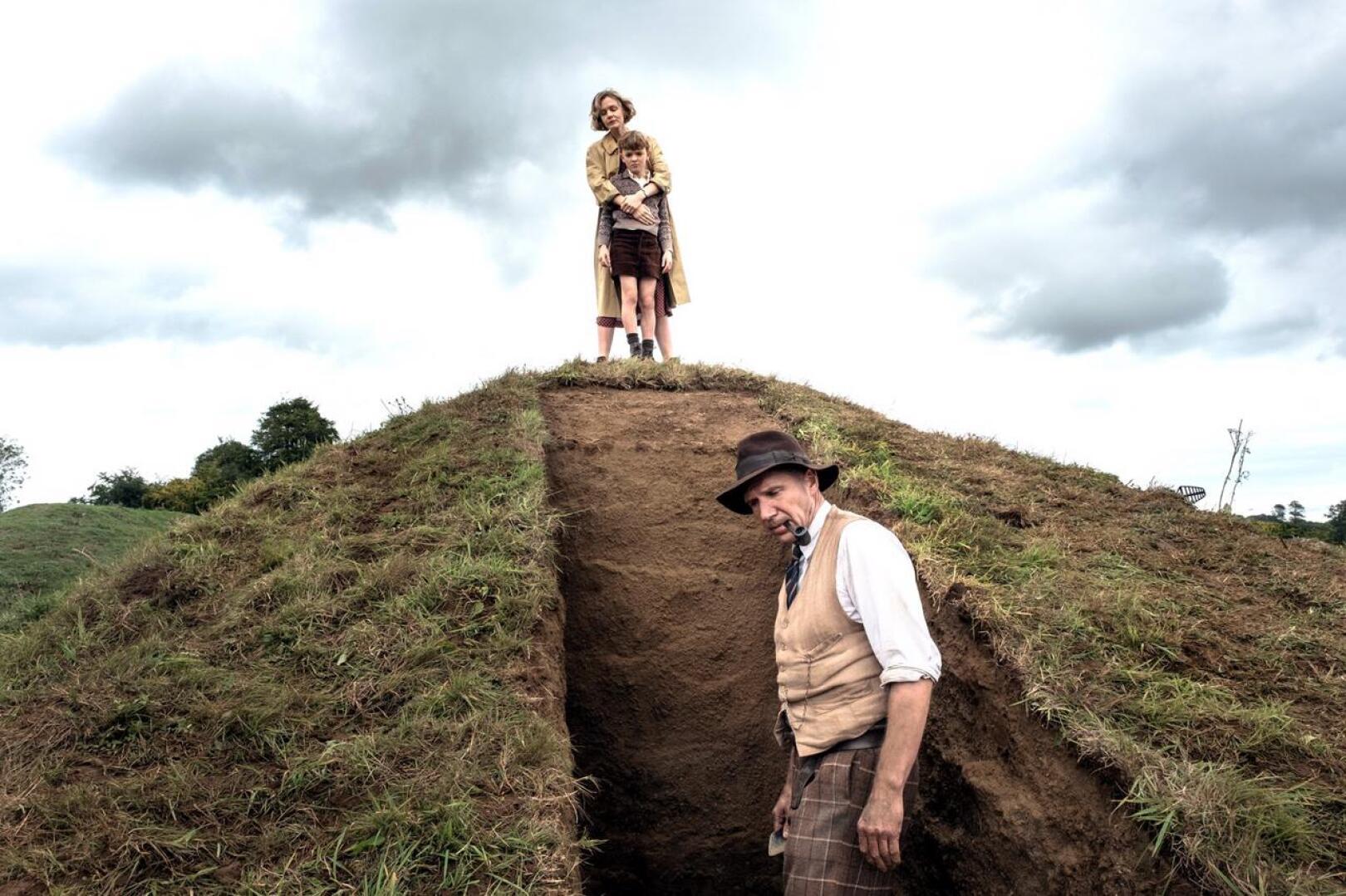 Sutton Hoon kaivauksilla Basil Brown (Ralph Fiennes), tilanomistaja Edith Pretty (Carey Mulligan) ja poika (Archie Barnes).