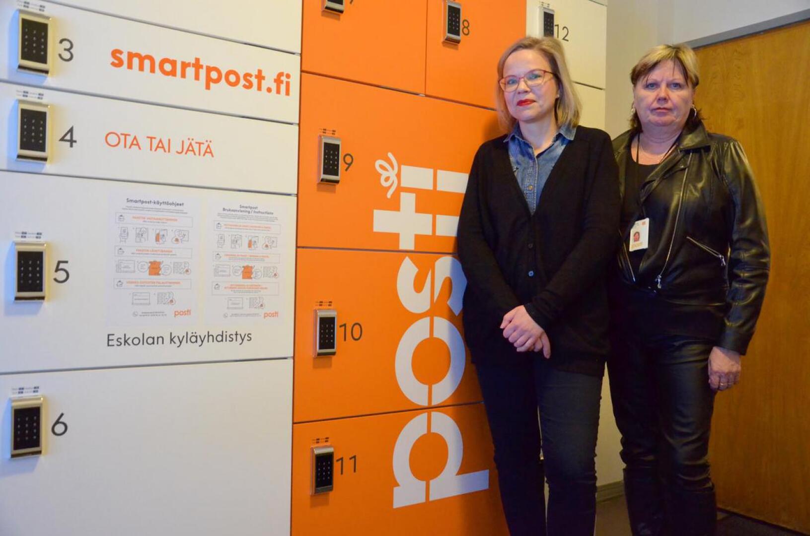Eskolan pakettiautomaatti sijaitsee Eskola-talon eteisessä, esittelevät kyläyhdistyksen projektityöntekijä Miia Tiilikainen (vas.) sekä Postin Pohjanmaan aluepäällikkö Sirkka-Liisa Korpi. Siinä on 17 erikokoista lokerikkoa. 