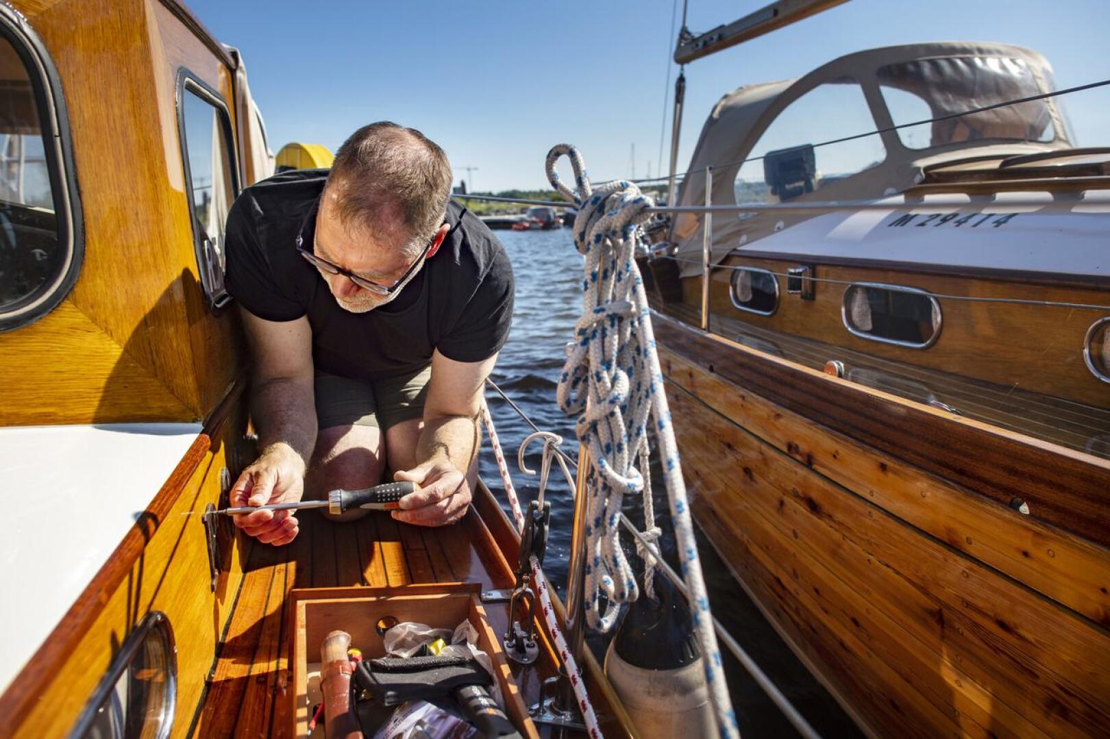 Erik Vierkens kiinnittää Rosan nimikirjaimia veneen kylkeen.